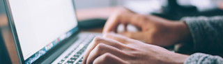 man typing on laptop at desk