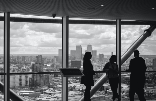 people looking out of a window overlooking the city