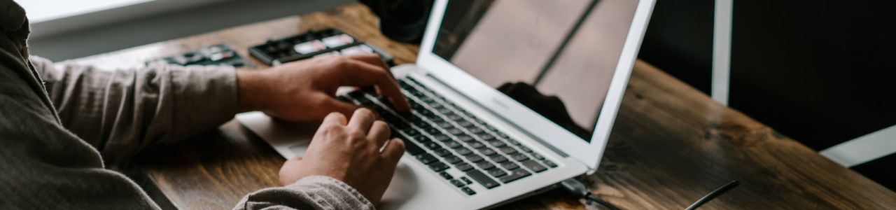 Man typing at laptop on desk 