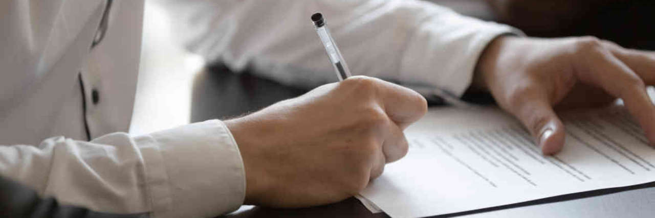 Business man signing a small business loan application after being approved