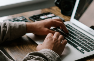 man typing on laptop at desk