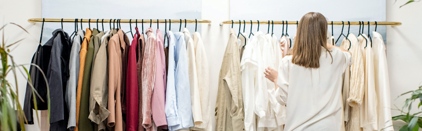 Woman sorting out rail of shopping in a shop