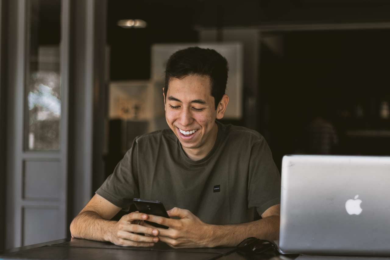 Man on phone by laptop