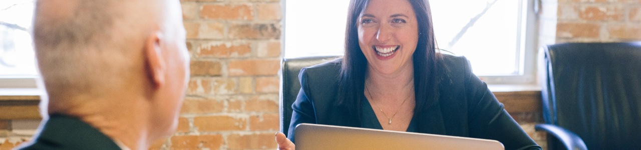 man facing woman whilst she's on her laptop