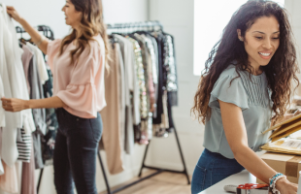 two women in shop sorting clothes rails