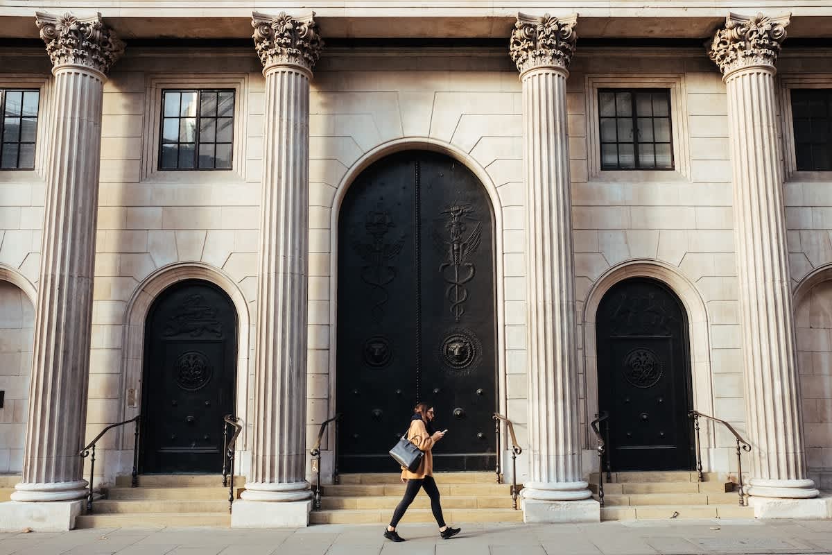 Woman walking in front of Bank of England 