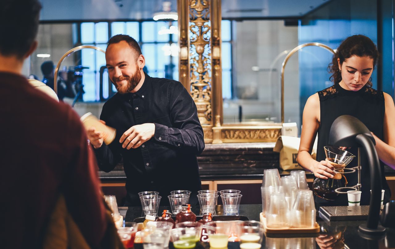 man and woman shaking cocktails at bar