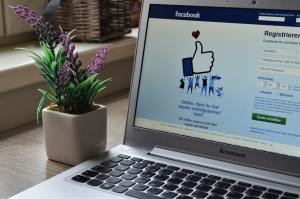 Facebook on laptop near plant
