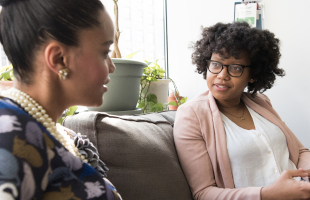 women working on sofa with a laptop