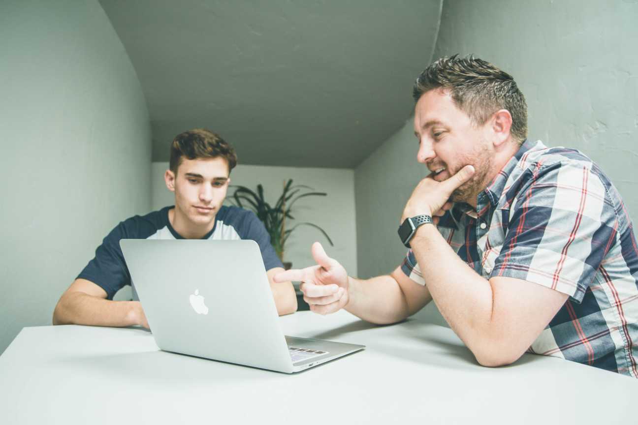 Two men working on laptop