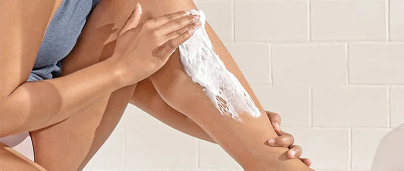 Kobieta nakłada krem do golenia Gillette Venus na nogę