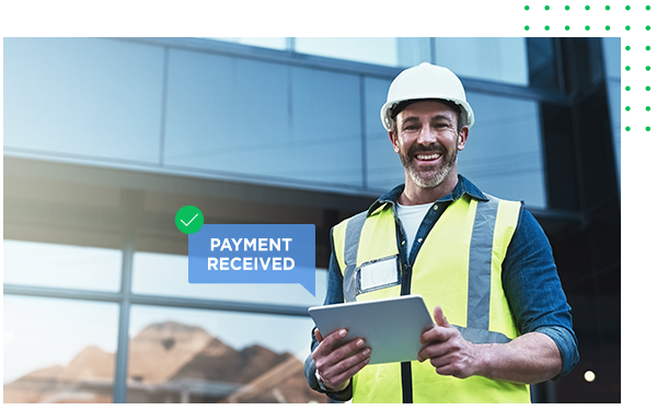 A construction manager smiles as he gets paid on his tablet.