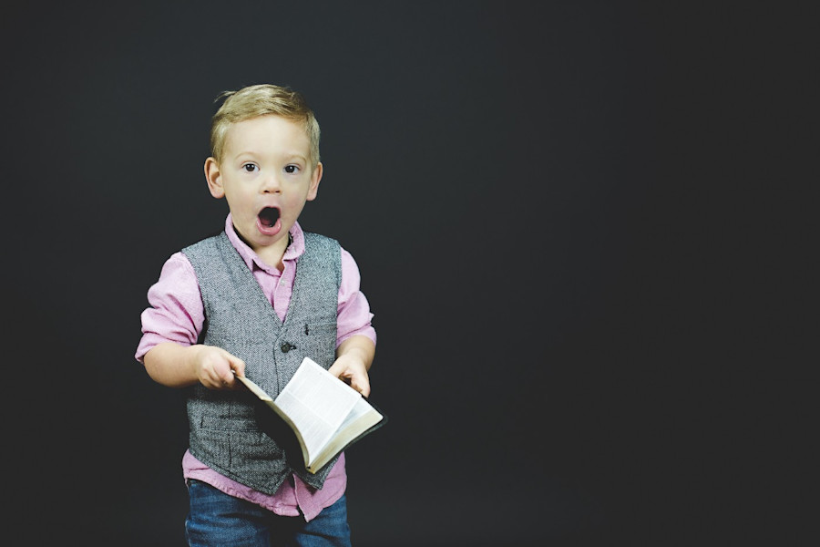 Young boy shocked holding book