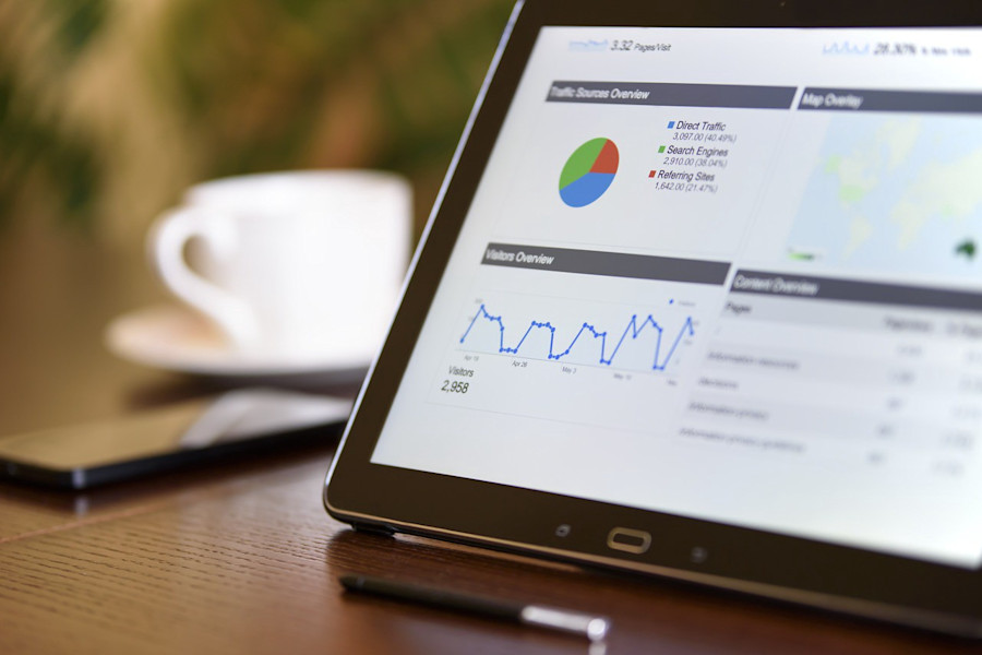 Tablet screen with graphs depicting website visitors and other statistics.