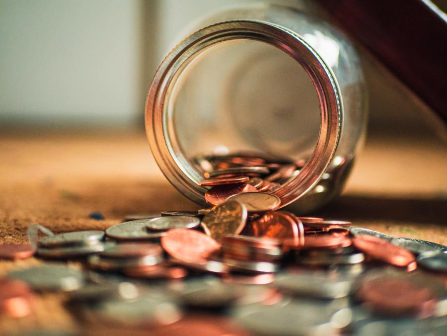 Josh Appel on Unsplash, photo of a jar of coins spilling over on a table