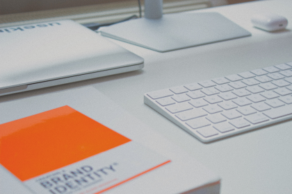 Brand identity book next to Apple keyboard.