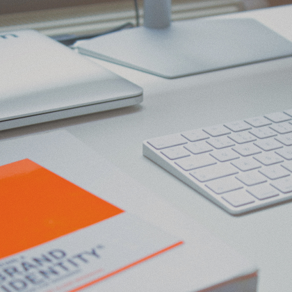 Brand identity book next to Apple keyboard.