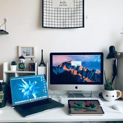Work from home setup with desktop, laptop, and ipad. 