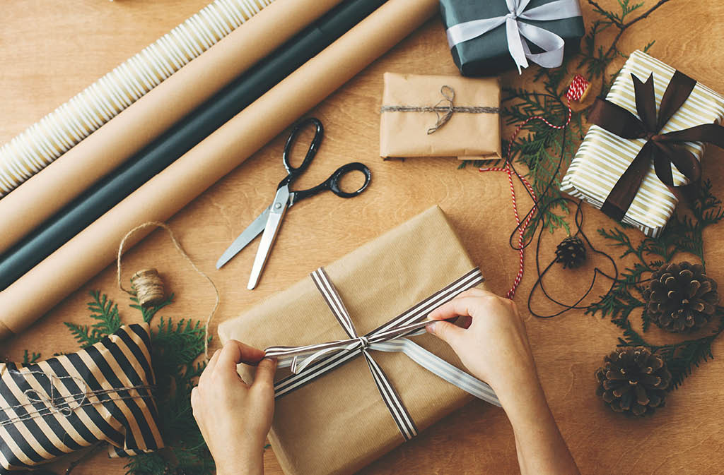 Scissors Cutting Christmas Ribbon While Wrapping A Present by