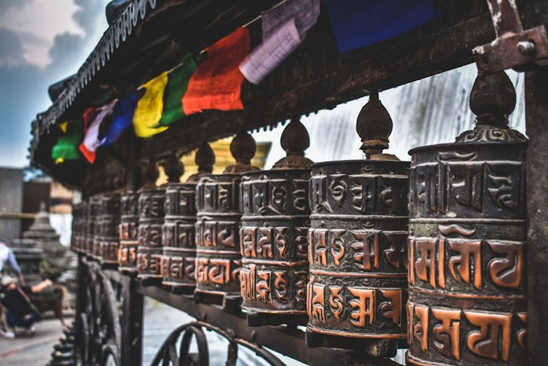 Prayer flags above Tibetan Buddhist prayer wheels