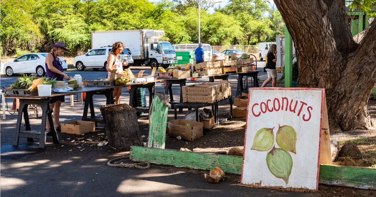 Hawaiian market selling various fruits, including fresh coconuts.