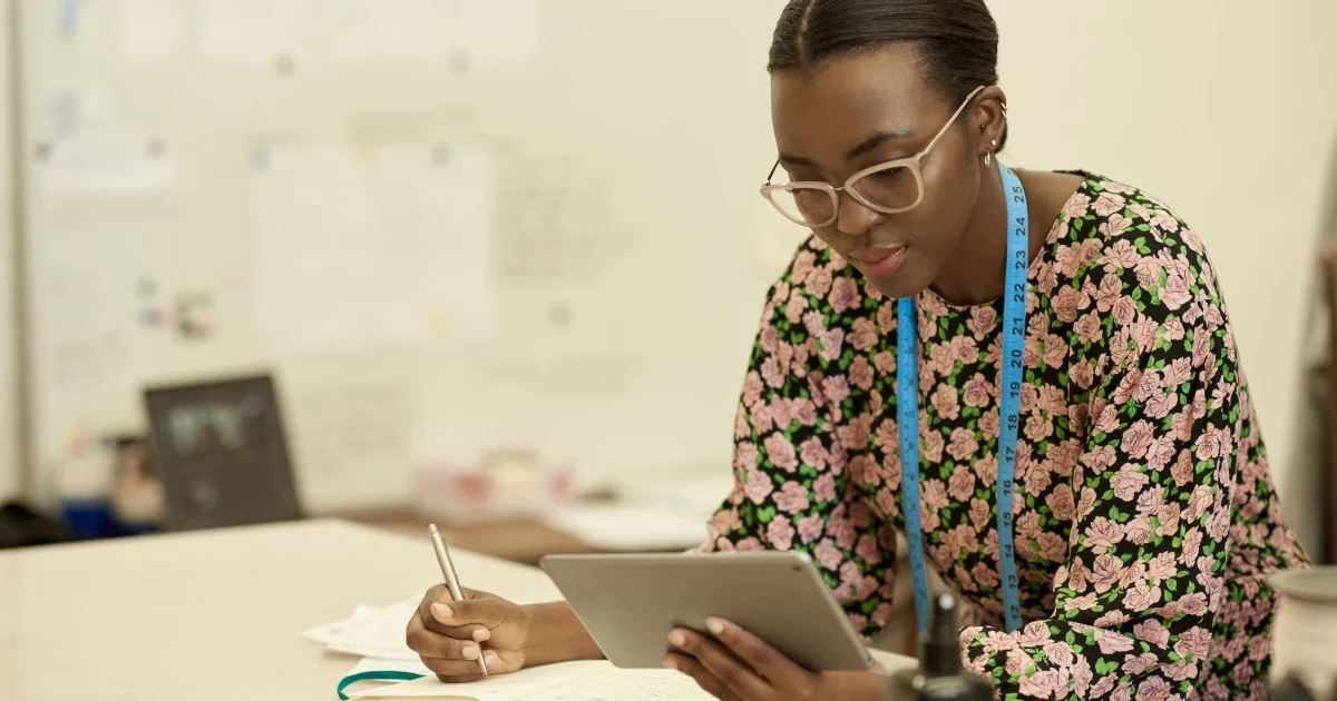 African female clothes designer working on a tablet in her studio