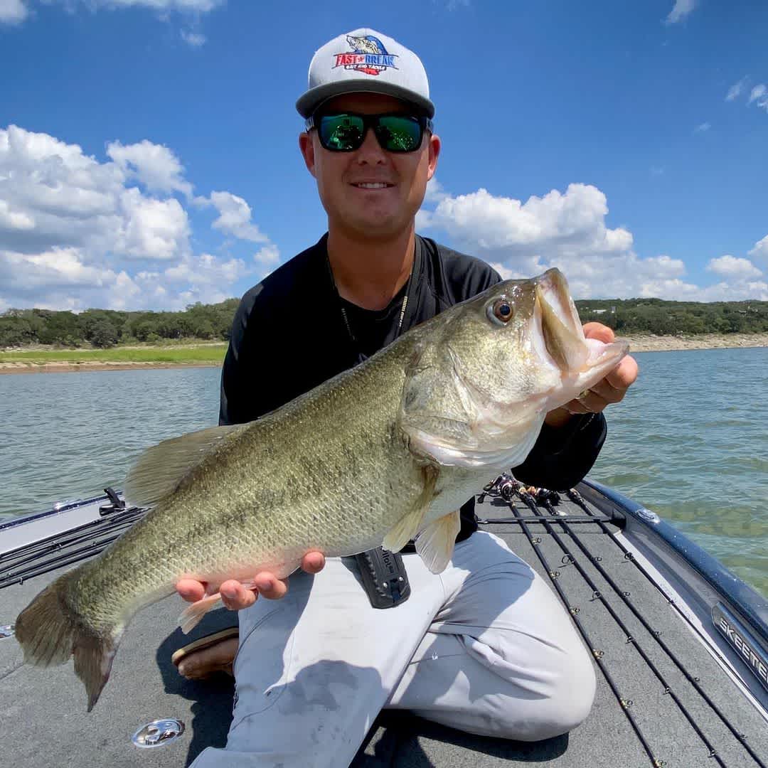 Torwick holding a bass fish on Lake Travis.