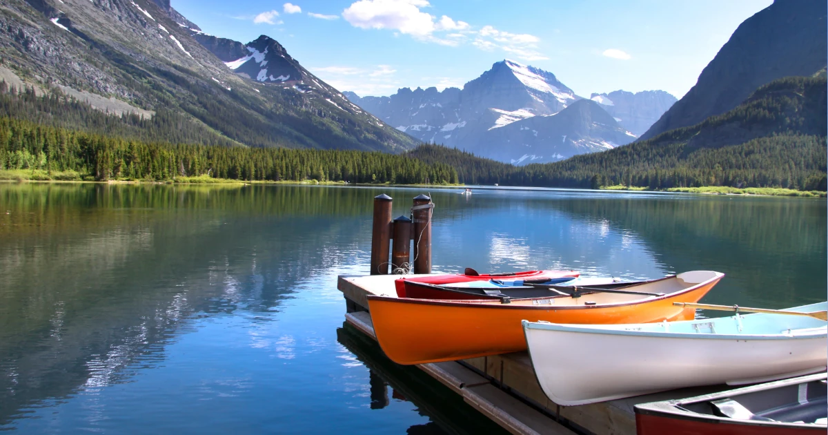 Canoes in front of a lake and mountains in Glacier National Park