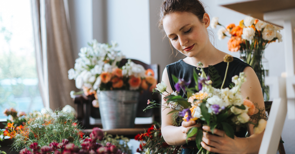 Woman working on floral arrangement
