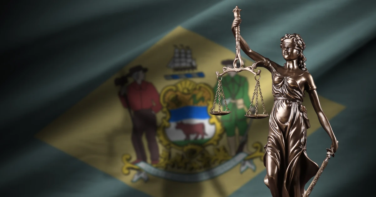 Delaware US state flag with statue of lady justice and judicial scales in dark room