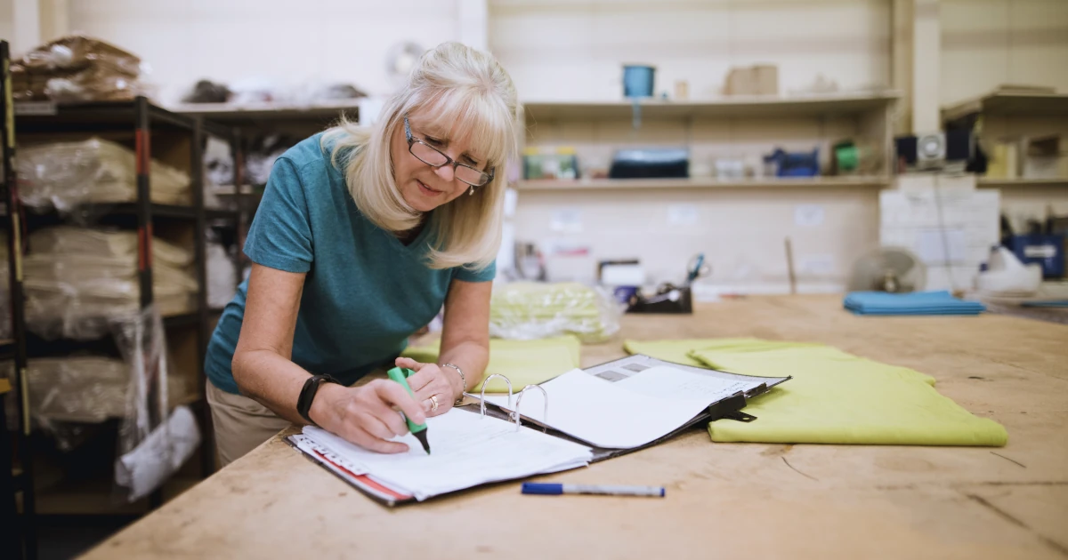 Senior businesswoman is doing paperwork in her stock factory