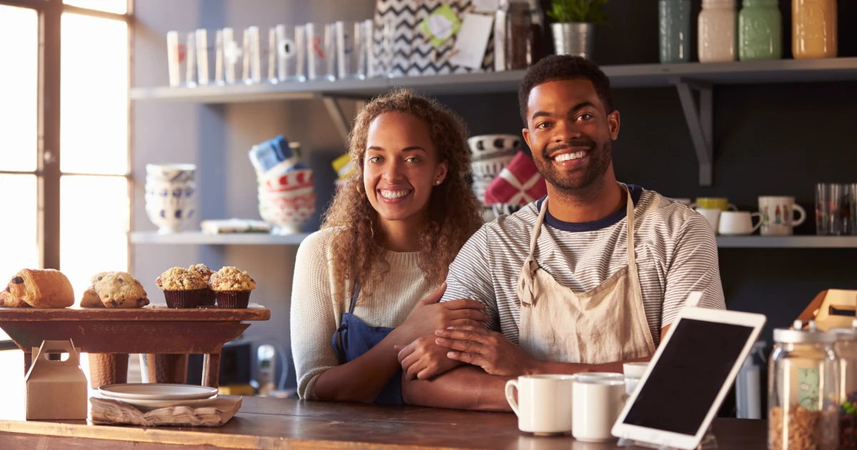 Portrait Of Couple Running Coffee Shop Behind Counter