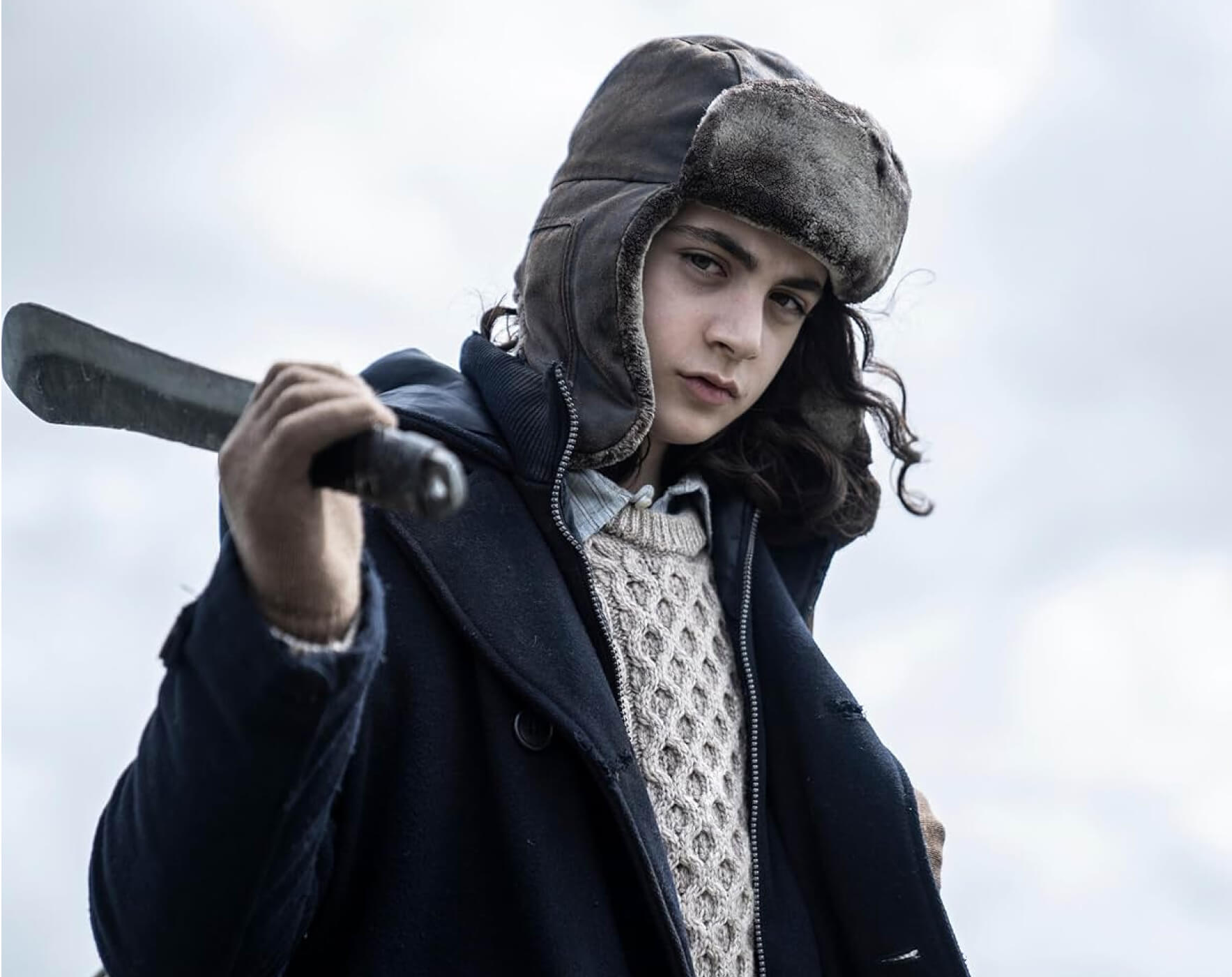 Young girl wearing a had and holding a weapon