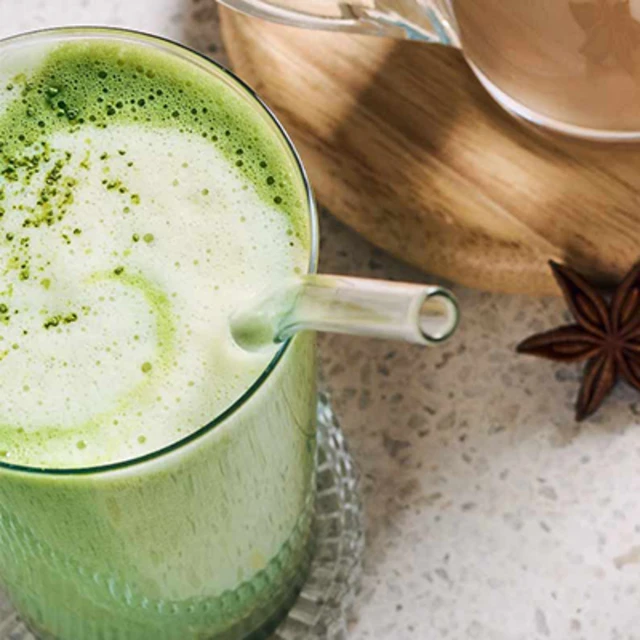 Verre transparent avec du matcha latte et une paille