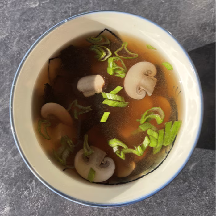 Bol de soupe miso traditionnelle japonaise avec tofu, champignons, wakame et oignon nouveau