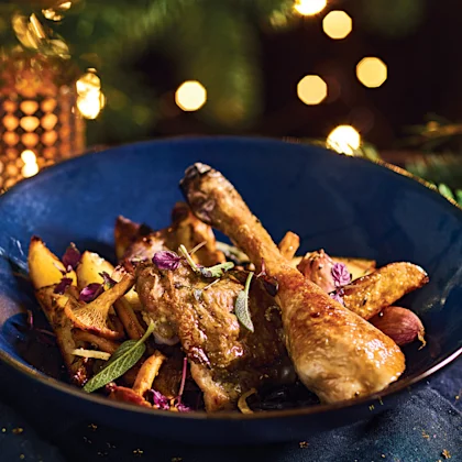 Cuisses de poulet rôti dorées au four servies dans une assiette avec herbes aromatiques