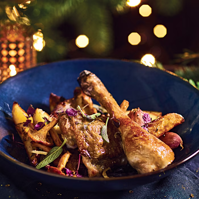 Cuisses de poulet rôti dorées au four servies dans une assiette avec herbes aromatiques