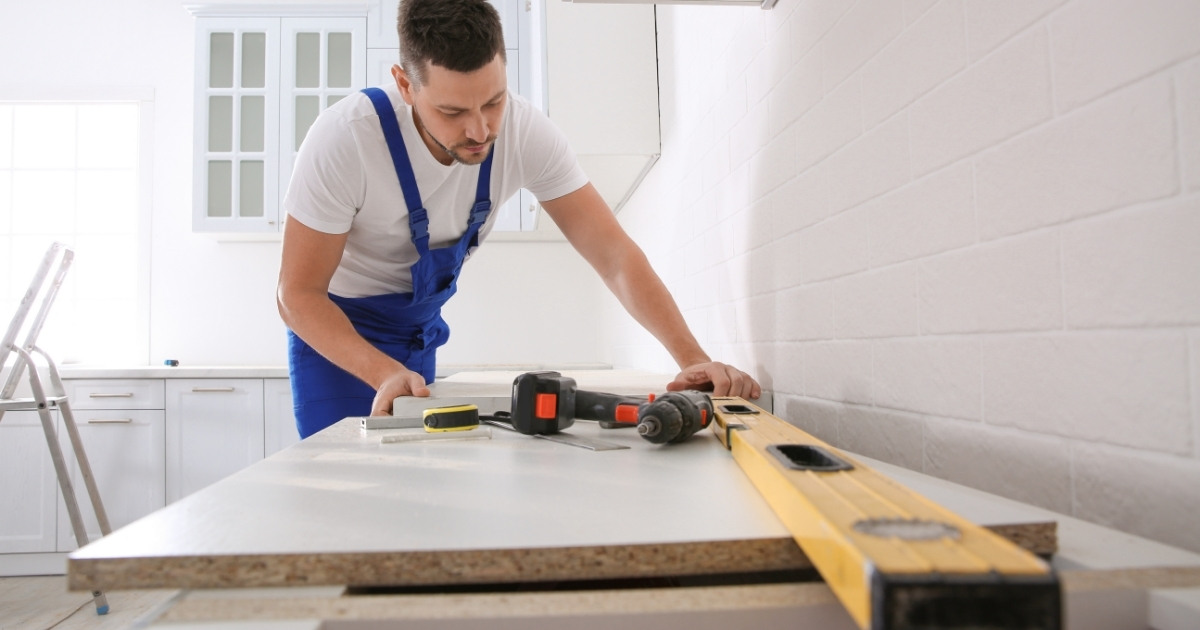 Worker Installing New Countertop in Modern Kitchen
