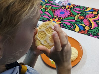 This Cub is carefully spreading the icing on her stamped skull biscuit.