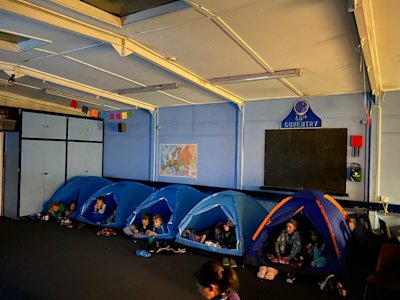 The Cubs are all snuggled up in their sleeping bags inside their tents, watching their film.