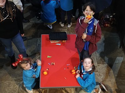 These two Beavers and their Young Leader are finishing up their Christingles, getting their loaded cocktail sticks stuck into their oranges.