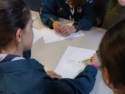 This group of Scouts is drawing their plans out for an electronic floor piano.