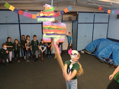 This Cub has just delivered a shattering blow to the piñata, spilling sweets from its cracked shell. The other Cubs are ready to run in and grab all the sweets they can from the floor.