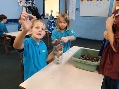 One of the Beavers exclaims, "I found a gem!" as she finds a piece of quartz in her gravel she's adding to her water filter.