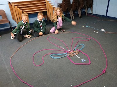 Three Cubs have made their huge fleur-de-lis from rope and a few craft materials. They look rightfully proud of themselves and their creation.