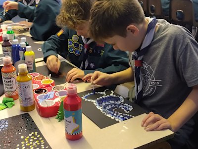 Concentrating hard on their designs, the Scouts are working on dot paintings inspired by Aboriginal art in Australia.