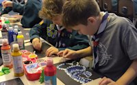 Concentrating hard on their designs, the Scouts are working on dot paintings inspired by Aboriginal art in Australia.