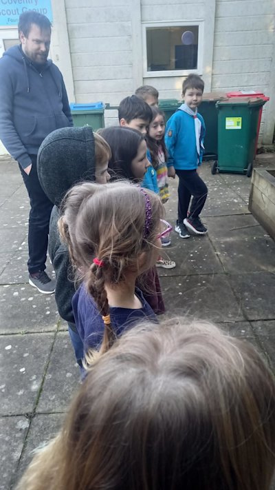 The Beavers are all lined up away from the campfire to sing "Fire's Burning", their choice of song.