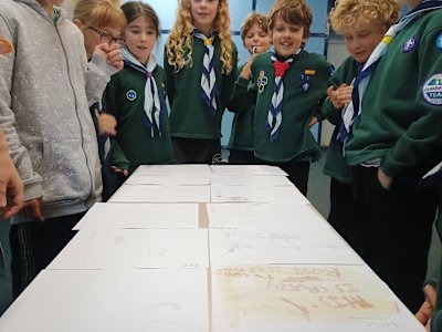 The Cubs are crowded around the table to see the bicarbonate of soda messages revealed with turmeric. They're really impressed and pleased with how well it's worked!