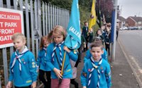 The Beaver flag bearer leads the parade toward the church, flanked by her colour guard. The flag bearers of the other sections are watching the tops of their flag poles, to make sure they don't catch on the tree branches overhanging the path.